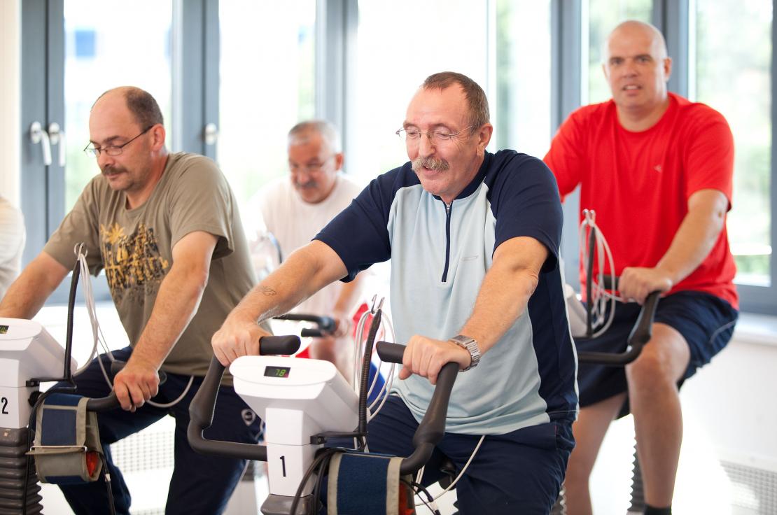 Vier Männer trainieren auf Ergometern im Rahmen eines Herzsports.